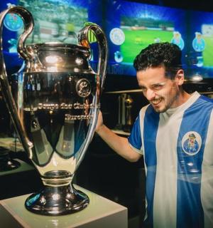 Ein Mann steht neben einer Champions-League-Trophäe