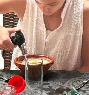 a woman pouring coffee into a bowl on a table