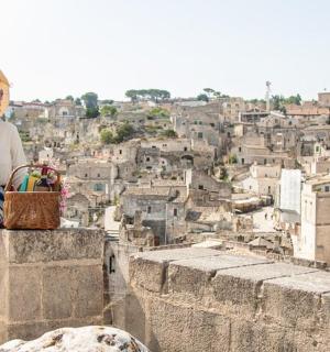 žena sedící na římse a dívající se na město