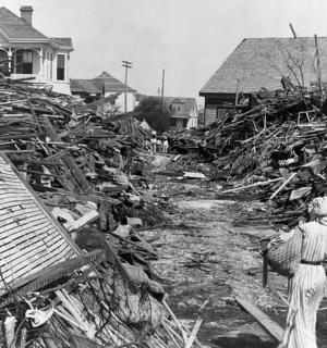 一名妇女站在一堆废墟前