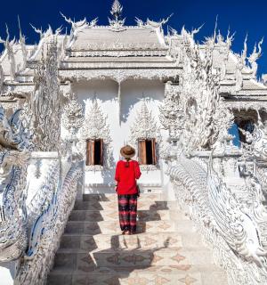一位妇女站在一座白色寺庙前