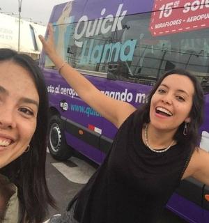 两名女子站在一辆紫色巴士前