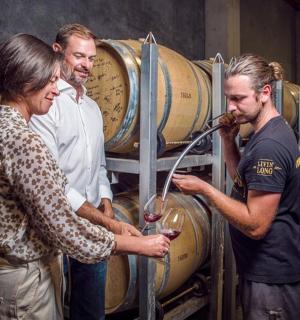 a group of men standing around barrels in a cellar