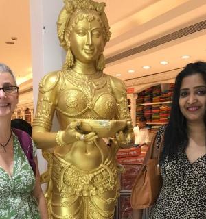 two women standing next to a statue in a store