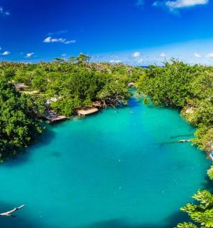 an aerial view of a blue lake in a forest