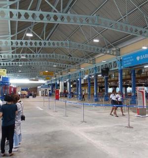 a group of people walking around an airport terminal