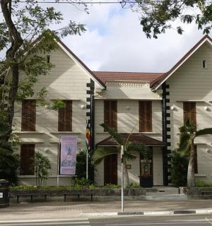 a large white building with trees in front of it