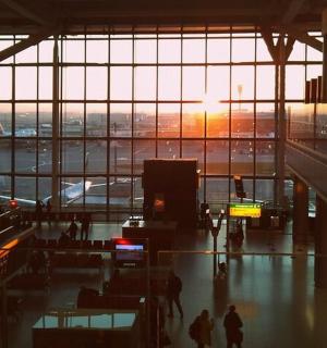 夕阳西下时，人们在机场航站楼内行走