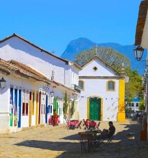 a group of buildings in a street with tables and chairs