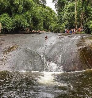 a person riding a bike on a rock in a river