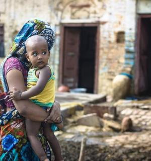 žena držící dítě na zádech