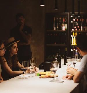 一群人坐在桌边,手里拿着酒杯