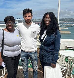 两名女子和一名男子站在阳台上