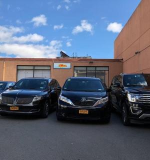 skupina čtyř aut zaparkovaných před budovou