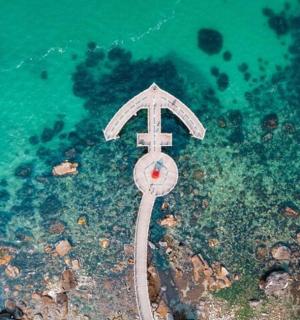 an aerial view of the ocean with a cross