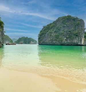 a beach in a body of water with limestone cliffs
