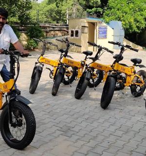 一名男子站在四辆黄色自行车前