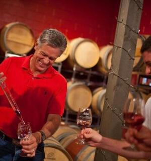 muž držící sklenici vína v sudu