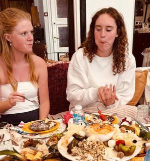 two women sitting at a table eating food