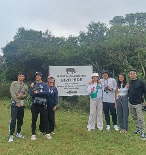 a group of people standing in front of a sign