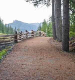 un camí de terra amb una tanca de fusta en un turó