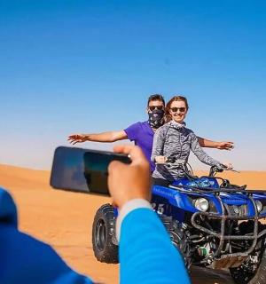 两个人在沙漠中骑着四轮摩托车