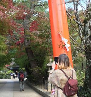 a woman walking down a sidewalk with an orange banner
