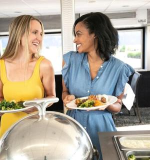两个女人站在厨房里，手里拿着盘子