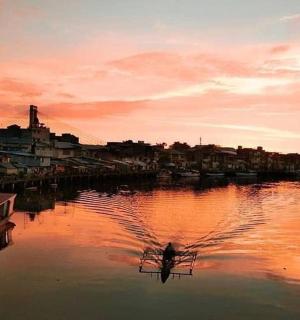 a boat is docked in a river at sunset