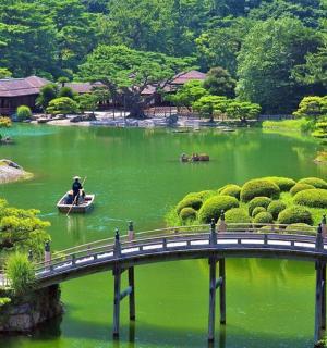 一座横跨绿色湖泊的桥，船上坐着一个人