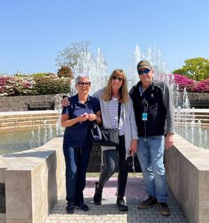 three people standing in front of a fountain