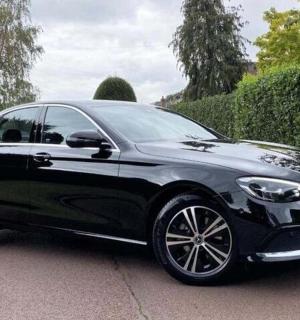 černé auto je zaparkované na příjezdové cestě