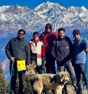 a group of people standing on a mountain with a dog