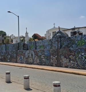 una pared cubierta de grafitis al costado de una calle