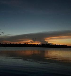 多云的天空下，水面上的日落