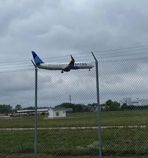 Letadlo vzlétá z ranveje za plotem