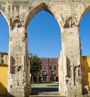 an old building with two arches in front of a building