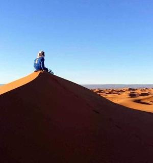 坐在沙漠土丘顶上的人