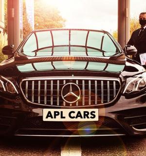 a man is standing next to a black car