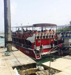 a red and white boat with people on it