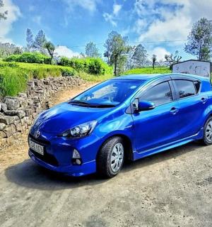 a blue car parked on a dirt road