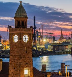 a clock tower with a clock on it in a harbor
