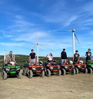 一群人站在四轮车和风车前