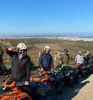 一群人骑着四轮摩托车在土路上行驶