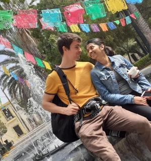 a man and a woman sitting in front of a fountain