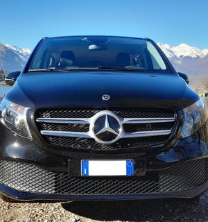 Černé auto Mercedes Benz zaparkované vedle jezera