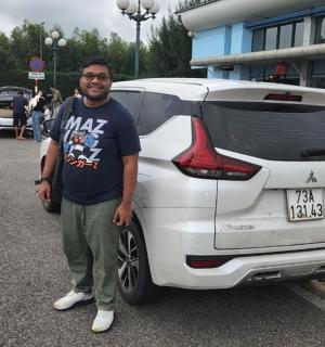 一名男子站在一辆白色汽车旁边