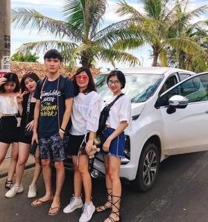 一群人站在一辆白色汽车旁边