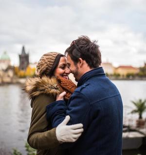 a man and a woman standing next to a river