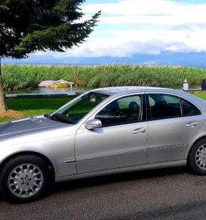 a silver car parked on the street next to a tree